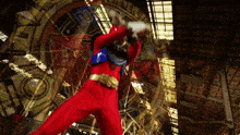 a man in a red superhero costume with the number 03 on his back