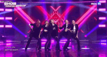 a group of women are dancing on a stage with a purple background .
