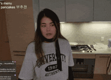 a woman wearing a white university authentic shirt