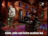 mads jolie and keira sesbian lex are playing a guitar and singing on stage