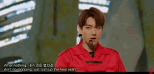 a young man in a red jacket is standing in front of a microphone on a stage .
