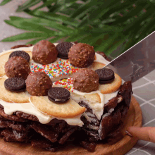 a person is cutting a cake with oreos and chocolate balls