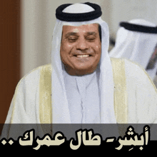 a man wearing a turban and a white robe with arabic writing on it