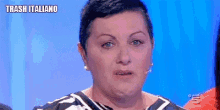 a woman with short hair is making a funny face and says trash italiano .