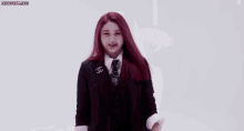 a woman with red hair is wearing a suit and tie and has a speech bubble around her head .
