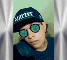 a man wearing a starter hat and sunglasses