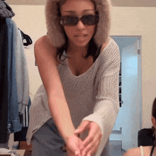 a woman wearing sunglasses and a furry hat