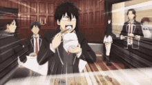 a man in a suit is eating food with chopsticks while a group of people are standing around him .