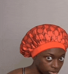 a woman is wearing a red hat with a gucci logo on it .