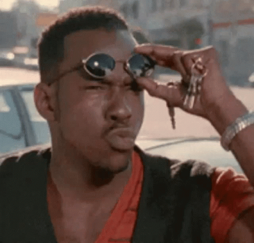 a man wearing sunglasses and holding keys is making a funny face .