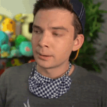 a man wearing a blue hat and a blue and white checkered scarf around his neck