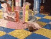 a pink merry go round is sitting on a yellow and blue checkered floor