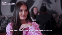 a woman in a pink jacket is talking about her feelings on some stuff