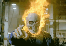 a ghost rider with flames coming out of his head is pointing at the camera