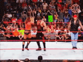 a wrestling match is going on in front of a crowd with a green sign that says ' i love you ' on it