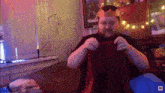 a man wearing a crown is sitting on a couch holding a red blanket