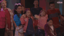 a group of kids are standing in front of a nick logo