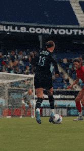 a soccer player with the number 13 on her back kicks the ball