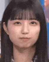 a close up of a woman 's face with a fringe .