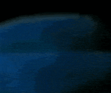 a blurry picture of a blue object in a dark room with a website visible in the corner