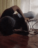 a person is laying on their back on the floor holding a cord