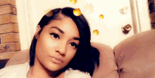 a woman is sitting on a couch with a door in the background and looking at the camera .