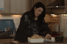 a woman prepares food in a kitchen with a tray of food on the counter