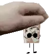 a hand is holding a cardboard box with a face and sunglasses on it .