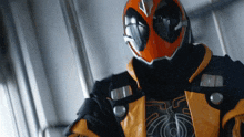 a close up of a person wearing an orange and black helmet