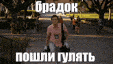 a man in a pink shirt is walking down a sidewalk with a bag on his shoulders and a foreign language caption