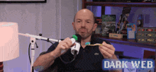 a man is holding a toothbrush in front of a microphone with the words dark web on the bottom right