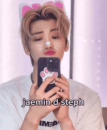 a man with a cat ear on his head is taking a picture of himself with a phone case that says cat paw