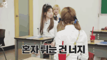 a group of girls are sitting at desks in a classroom with the word twice on the bottom