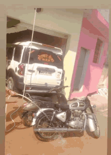 a motorcycle is parked in front of a white suv with a license plate that says j07 df 6113