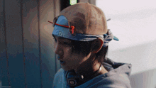a man wearing a baseball cap and headphones with a bandana around his head .