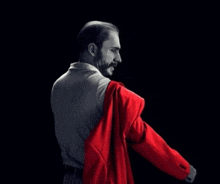a man in a suit is taking off his jacket
