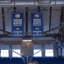 a sign that says 2010 and 2011 hangs from the ceiling of a basketball arena