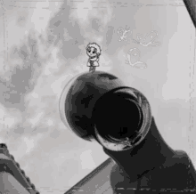 a black and white photo of a person holding a glass with a cartoon character on top of it