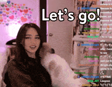 a woman sitting in front of a screen that says let 's go on it