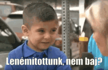 a young boy in a blue shirt is talking to a woman in a parking lot ..