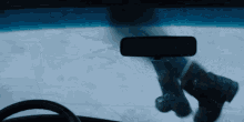 the rear view mirror of a car shows a person walking in the snow