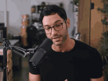 a man wearing glasses speaking into a microphone