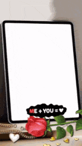 a tablet with a red rose and the words me + you = love on it