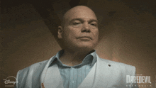 a bald man in a white suit with the word daredevil on it