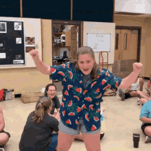 a girl in a watermelon shirt is standing in a room