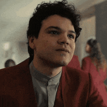 a close up of a man 's face with a red jacket