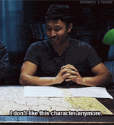a man is sitting at a table with a map and says " i don t like this character anymore "