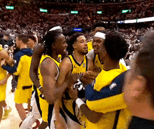 a group of basketball players are hugging each other with one wearing a jersey that says nc