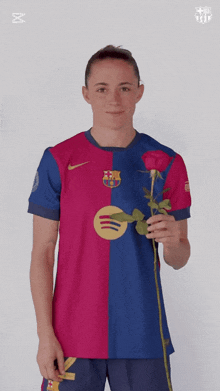 a woman wearing a barcelona jersey is holding a rose