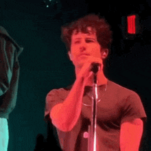 a man is standing in front of a microphone on a stage .